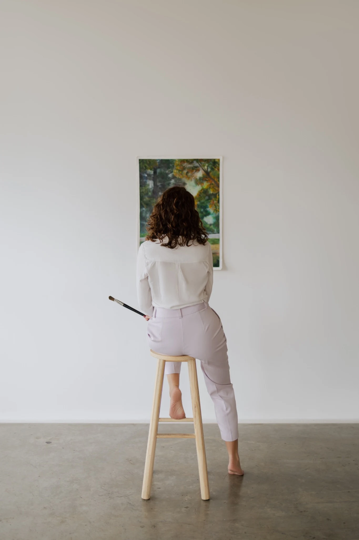 Ana Steffler diante de uma pintura em seu ateliê